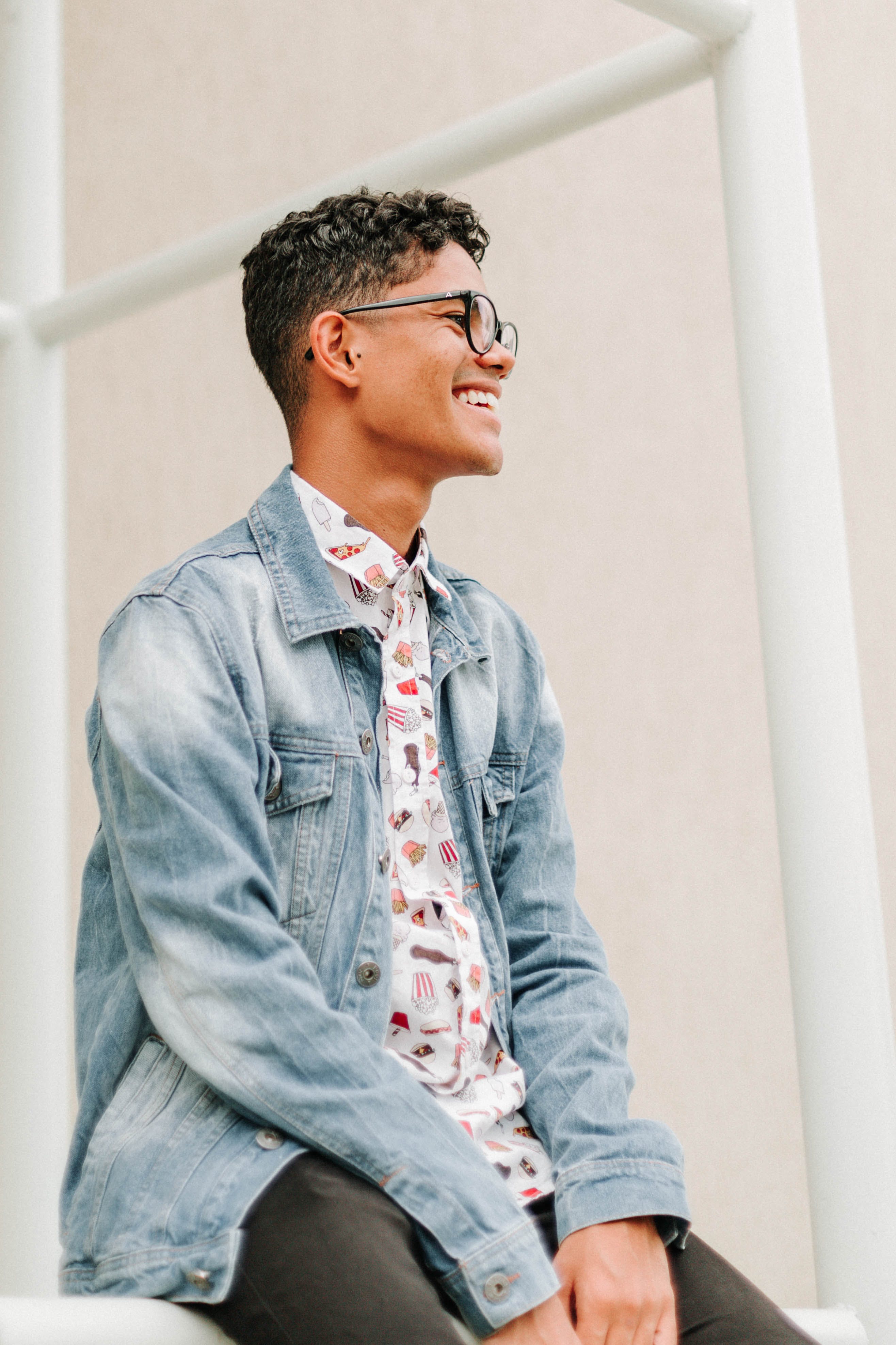 A man wearing glasses smiling into the distance