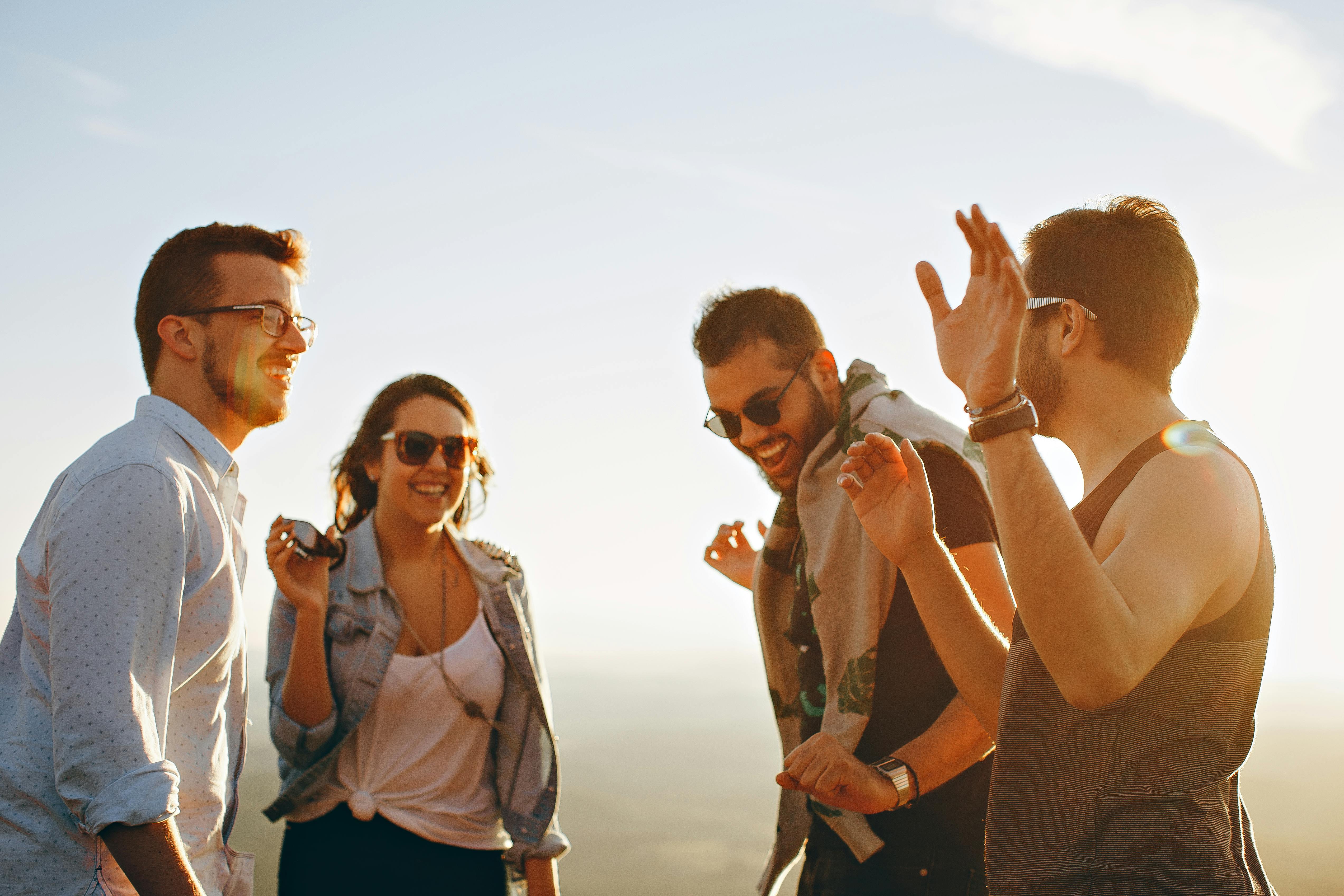 Four people outside, wearing glasses and sunglasses